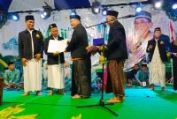 Salah satu ustad Masjid Moetiah menerima sertifikat metode UMI disaksikan ribuan jamaah Ngaji Akhir Tahun.