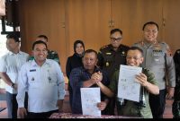 Ketua Grib Jaya Kabupaten Blora, Sugiyanto, dan Ketua Ormas Pemuda Pancasila Kabupaten Blora, Munaji menunjukan surat kesepakatan damai di hadapan Bupati Blora Arief Rohman dan Forkompinda di Rumah Dinas Bupati.